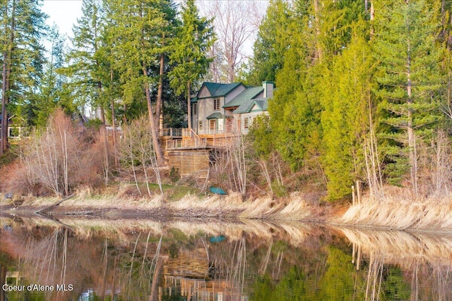 view of yard featuring a deck with water view and stairs