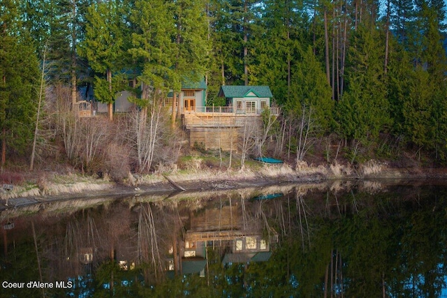 drone / aerial view with a wooded view and a water view