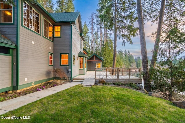 exterior space featuring crawl space, a wooden deck, and a lawn