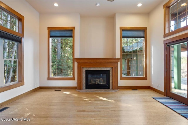 unfurnished living room featuring visible vents, baseboards, and wood finished floors