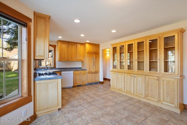 kitchen featuring recessed lighting, white dishwasher, glass insert cabinets, and dark countertops