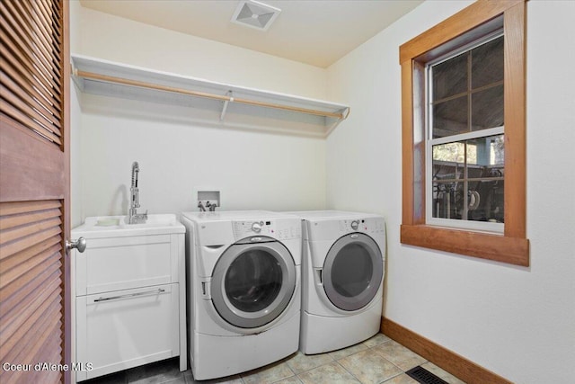 laundry room featuring visible vents, a sink, baseboards, cabinet space, and washer and clothes dryer