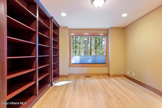 unfurnished room with recessed lighting, visible vents, baseboards, and wood finished floors