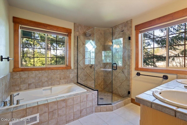 full bathroom featuring a shower stall, plenty of natural light, a garden tub, and a sink