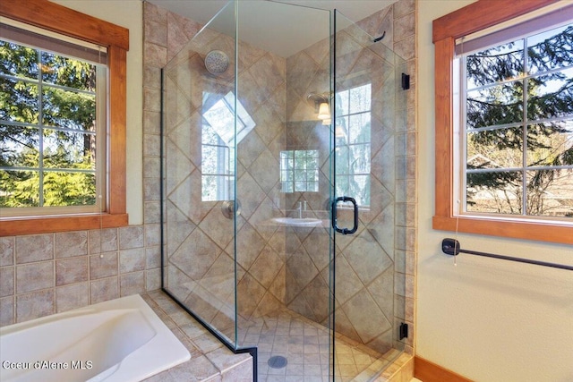 full bathroom featuring a shower stall, a wealth of natural light, and a garden tub