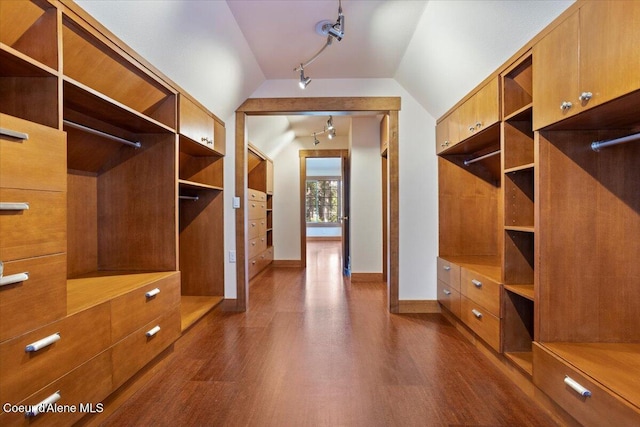 walk in closet with dark wood-style floors and vaulted ceiling