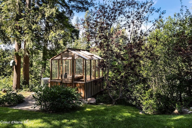 view of yard featuring an outbuilding and a greenhouse