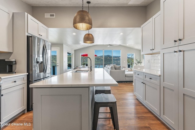 1967 W Cottonwood Rd, Worley, ID 83876 - kitchen with visible vents, a sink, light countertops, a breakfast bar, and wood finished floors