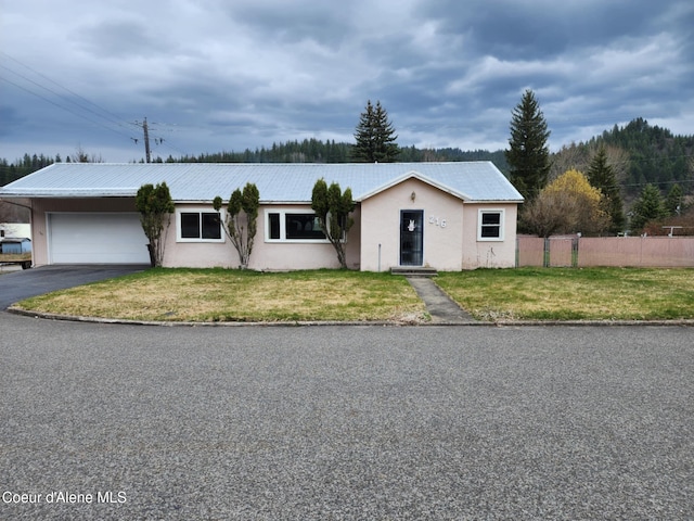 216 W Oak Ave, Osburn, ID 83849 - ranch-style house with an attached garage, aphalt driveway, stucco siding, and a front lawn