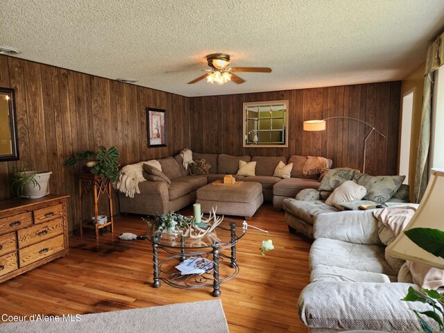 216 W Oak Ave, Osburn, ID 83849 - living room featuring a textured ceiling, wood finished floors, ceiling fan, and wooden walls