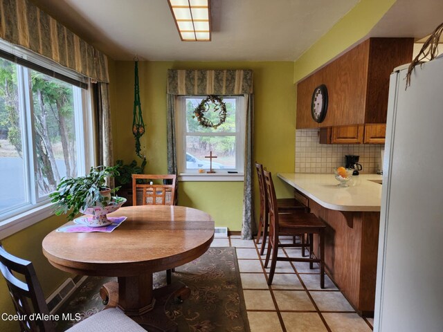 216 W Oak Ave, Osburn, ID 83849 - dining space with plenty of natural light, light tile patterned floors, visible vents, and baseboards