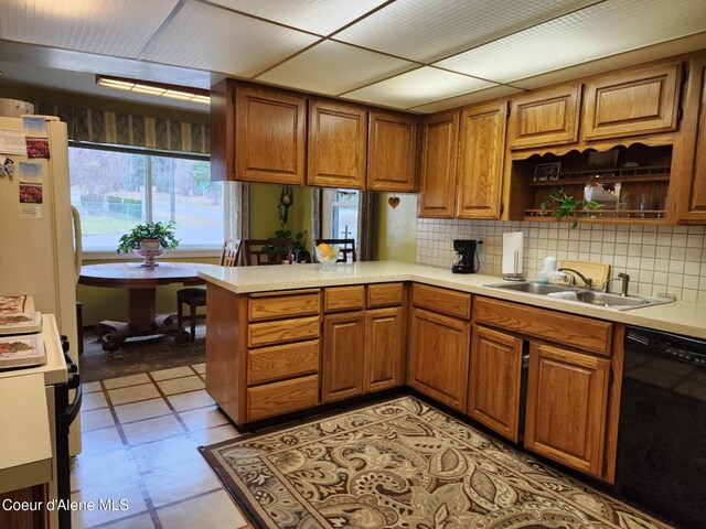 216 W Oak Ave, Osburn, ID 83849 - kitchen with brown cabinetry, a peninsula, black dishwasher, light countertops, and a sink