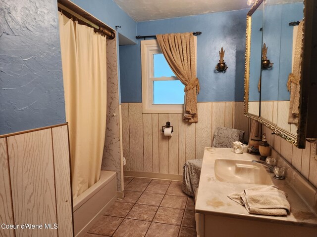 216 W Oak Ave, Osburn, ID 83849 - full bath featuring vanity, tile patterned flooring, wood walls, wainscoting, and shower / bath combo with shower curtain