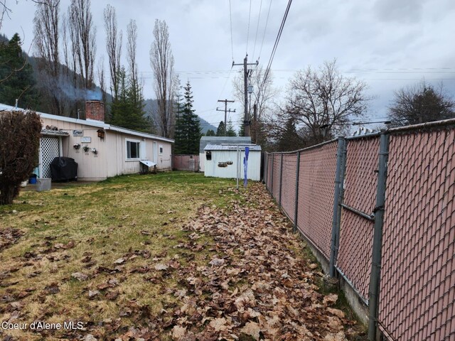 216 W Oak Ave, Osburn, ID 83849 - view of yard featuring an outbuilding, a fenced backyard, and a storage unit