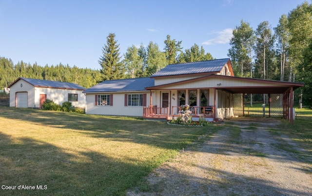 rear view of house featuring covered porch, dirt driveway, metal roof, a lawn, and a carport
