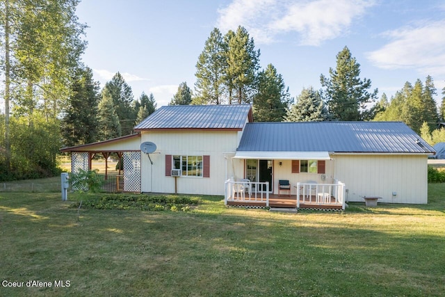 back of property featuring metal roof, a wooden deck, and a lawn