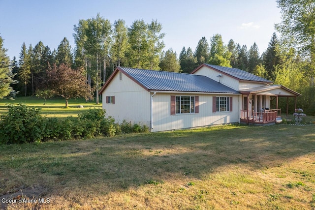 exterior space with a yard, metal roof, and a porch