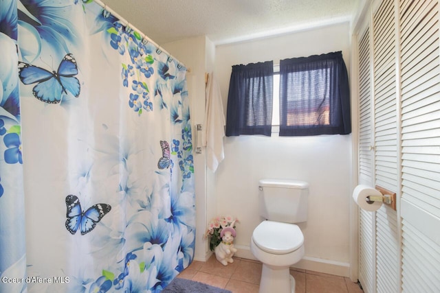 bathroom featuring tile patterned floors, toilet, and a shower with curtain