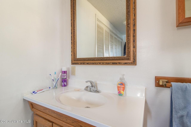 bathroom featuring a textured ceiling and vanity