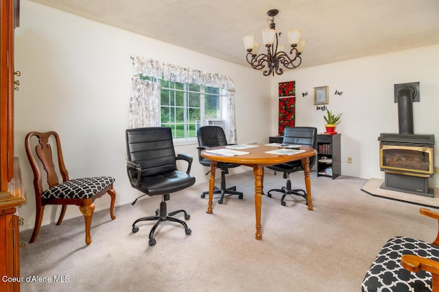 carpeted home office with a wood stove and a chandelier