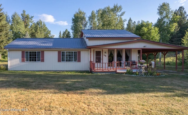 back of property with covered porch, metal roof, a lawn, and a carport