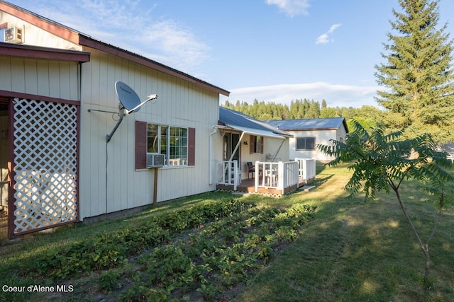 view of home's exterior with a yard, a deck, and cooling unit