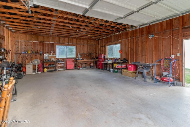 garage with a workshop area and wood walls