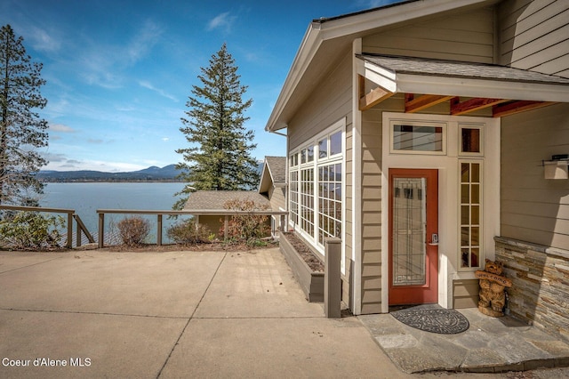 3765 Bottle Bay Rd, Sagle, ID 83860 - property entrance with a patio, a water and mountain view, and roof with shingles