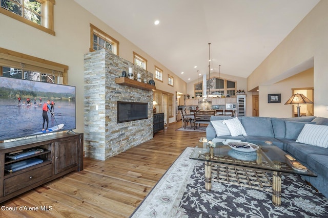 3765 Bottle Bay Rd, Sagle, ID 83860 - living area featuring recessed lighting, a stone fireplace, high vaulted ceiling, and wood finished floors