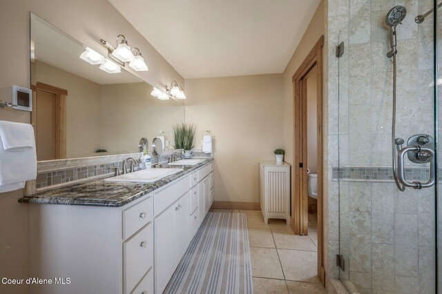3765 Bottle Bay Rd, Sagle, ID 83860 - full bathroom with a shower stall, tile patterned flooring, toilet, a sink, and double vanity