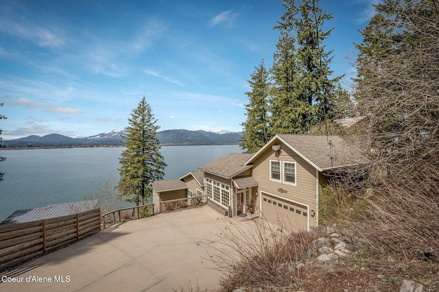 3765 Bottle Bay Rd, Sagle, ID 83860 - exterior space featuring an attached garage, fence, a water and mountain view, and driveway