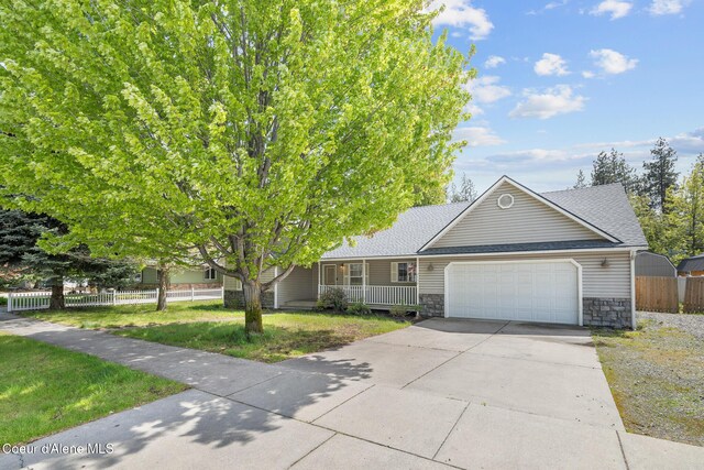 2450 E Black Forest Ave, Post Falls, ID 83854 - view of front facade with stone siding, an attached garage, driveway, roof with shingles, and a porch