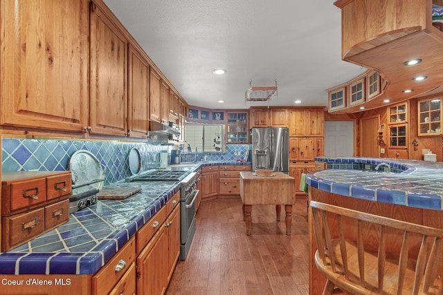 kitchen with tile counters, recessed lighting, appliances with stainless steel finishes, and backsplash