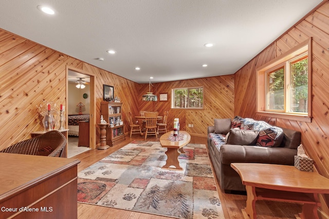 living room featuring recessed lighting, wood walls, and wood finished floors