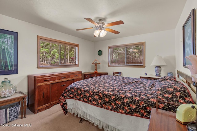 bedroom with light colored carpet and a ceiling fan