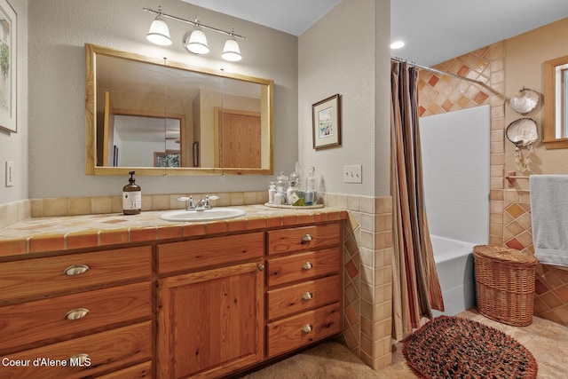 bathroom with vanity, shower / bath combination with curtain, and tile walls