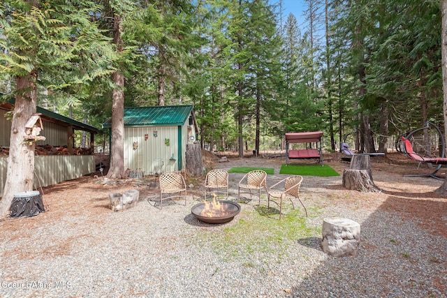 view of yard with an outbuilding, a fire pit, and a storage shed