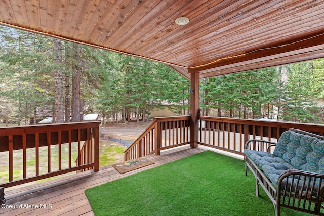 wooden terrace featuring a lawn