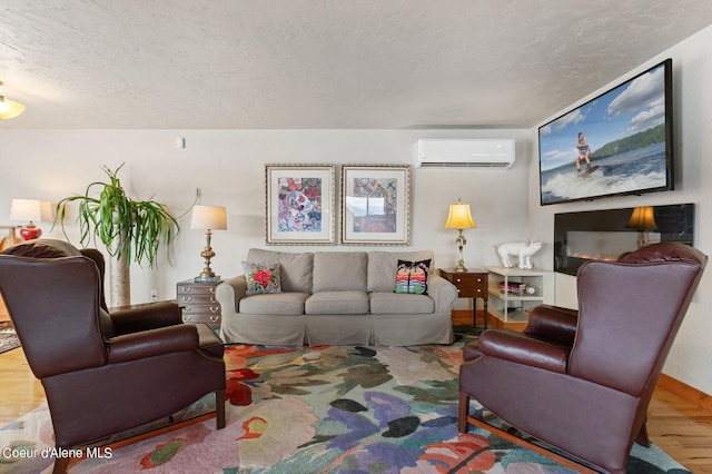 living room with a textured ceiling, a wall unit AC, and wood finished floors