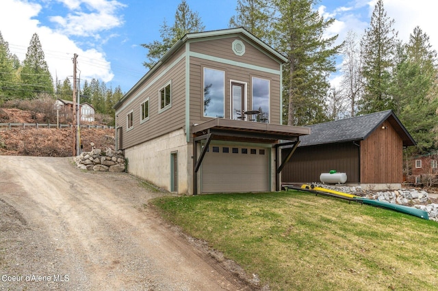 view of front facade with a garage, a front yard, and dirt driveway