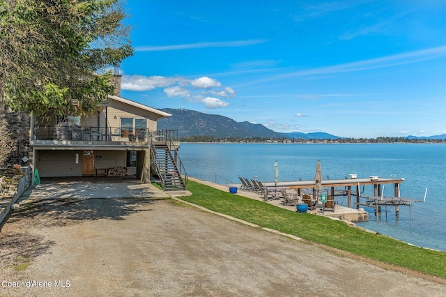 view of dock with a water and mountain view and stairs