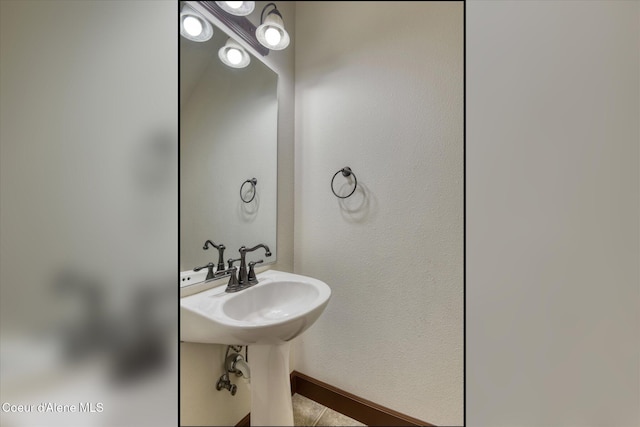 bathroom featuring a sink and baseboards