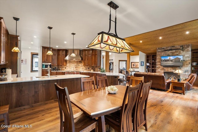 dining room with built in features, light wood-style flooring, recessed lighting, and vaulted ceiling