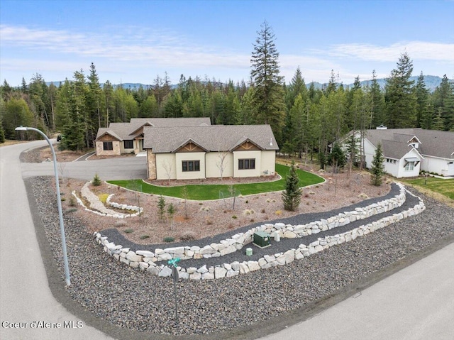 view of front of home featuring a view of trees and driveway