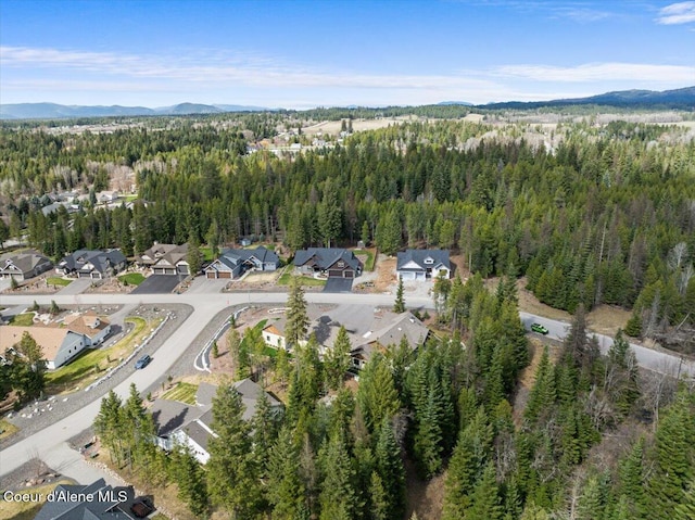 birds eye view of property featuring a forest view, a mountain view, and a residential view