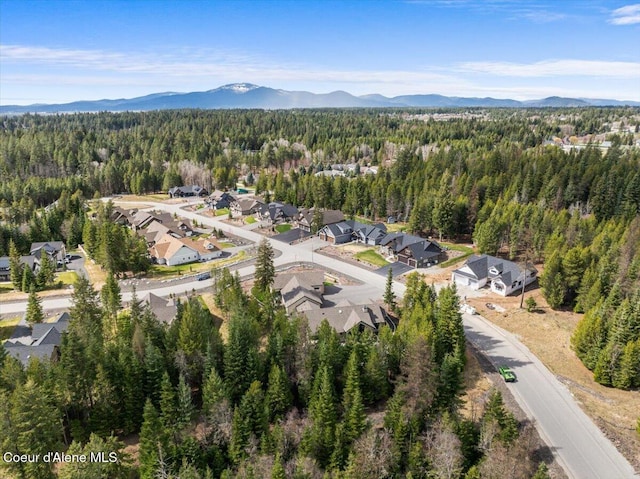 birds eye view of property featuring a wooded view, a mountain view, and a residential view
