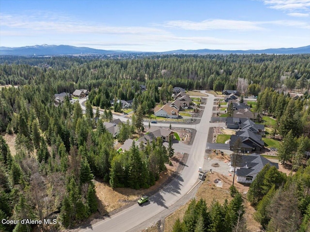 birds eye view of property featuring a mountain view, a view of trees, and a residential view