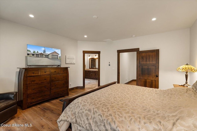 bedroom featuring recessed lighting, ensuite bathroom, baseboards, and wood finished floors