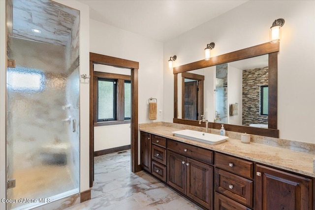 full bath with a shower stall, marble finish floor, baseboards, and vanity