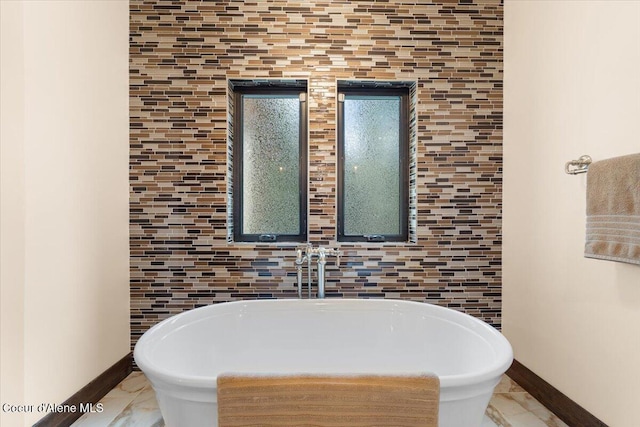 full bath with baseboards and a freestanding bath